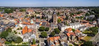 Vue de Braine-l'Alleud avec une rue animée, des maisons typiques et services de débouchage Braine-l'Alleud disponibles.