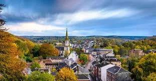 Plombier Eupen en service dans une rue pittoresque de la ville avec des bâtiments historiques typiques en arrière-plan