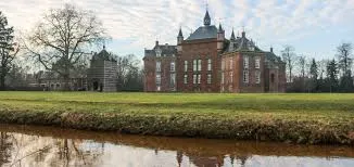 Scène urbaine de Grâce-Hollogne avec un plombier professionnel en action à proximité d'un bâtiment typique local.