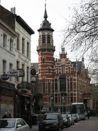 Scène urbaine à Jette avec égoutiers en action pour le débouchage, vue sur rues typiques et bâtiments locaux.