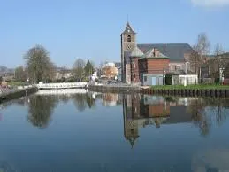 Rue animée de La Louvière avec camion Débouchage La Louvière en action, devant une façade typique belge.