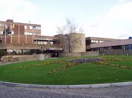Rue de Sambreville avec un camion de débouchage en action devant des maisons traditionnelles et des commerces locaux